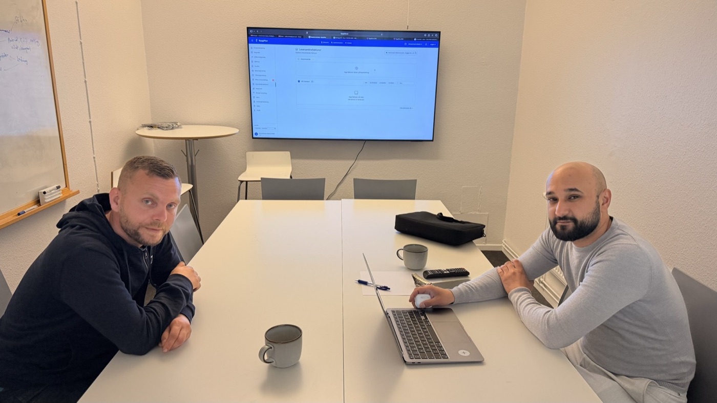 Två personer från HBG VVS vid mötesbordet med Byggplan uppe på skärmen